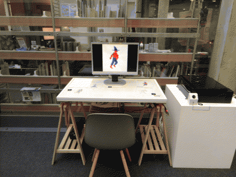 l'espace de l'installation avec une table pour dessiner, un scanner et un écran pour voir l'avencement du projet en direct